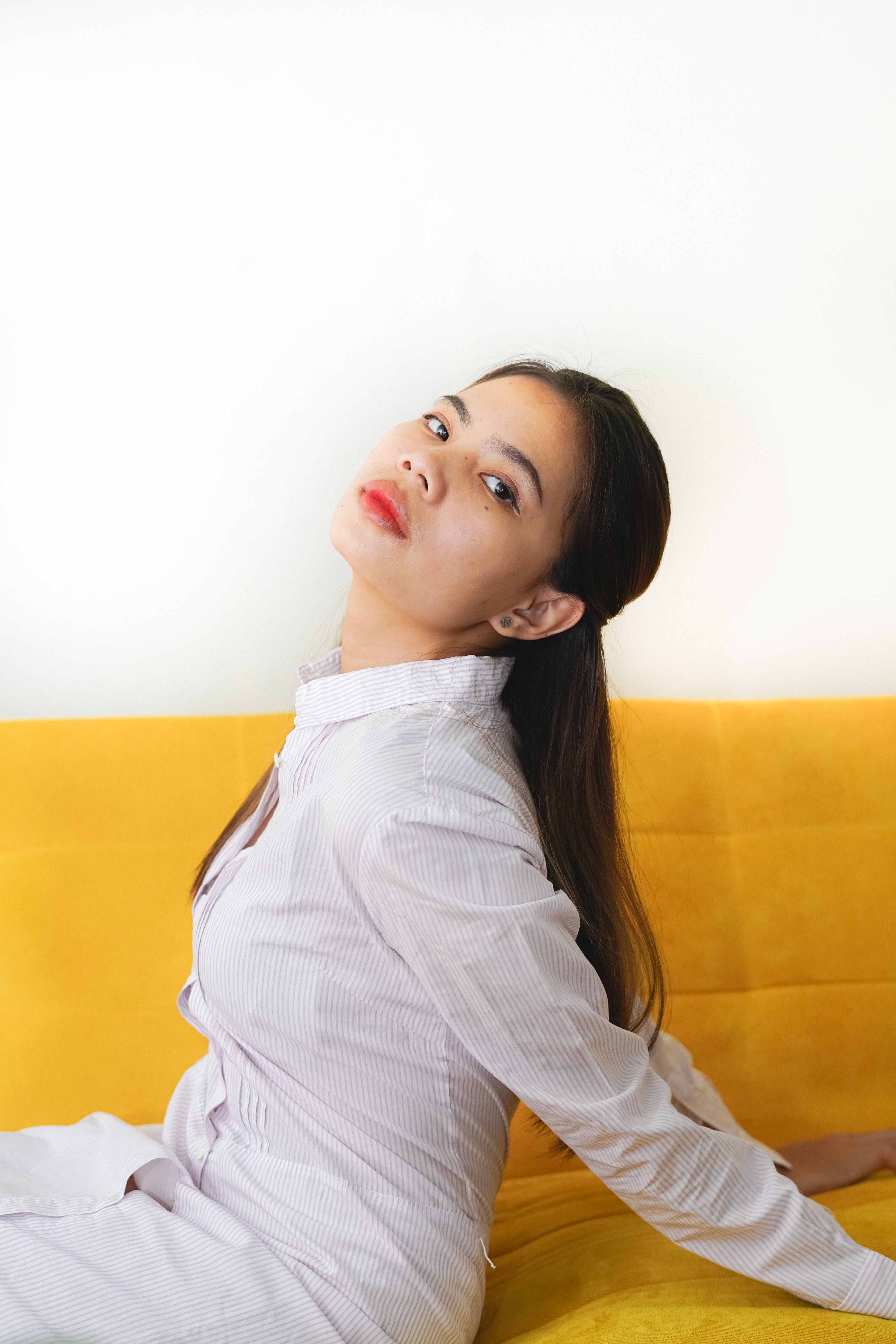 Woman in White Long Sleeves Sitting on the Couch · Free Stock Photo
