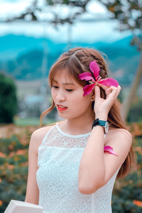 Brown Haired Woman in White Sleeveless Top in Bokeh Photography