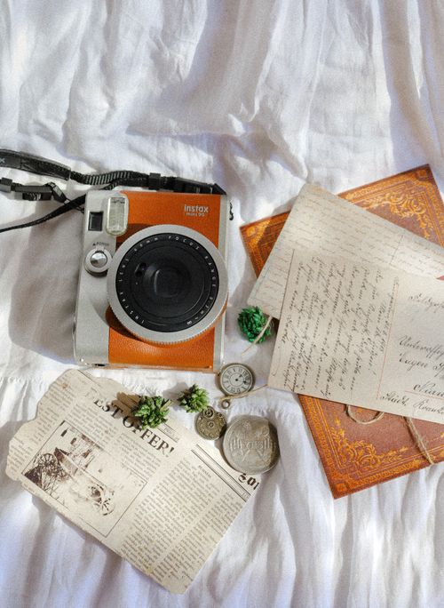 Free Flat lay of a vintage camera with old letters and coins on a fabric surface, ideal for nostalgic themes. Stock Photo