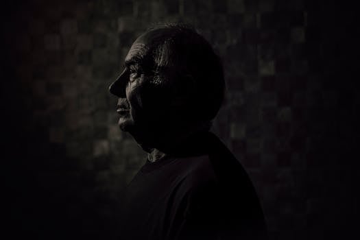 黑暗背景上，一位老人的剪影凸显出智慧与经验的纹理