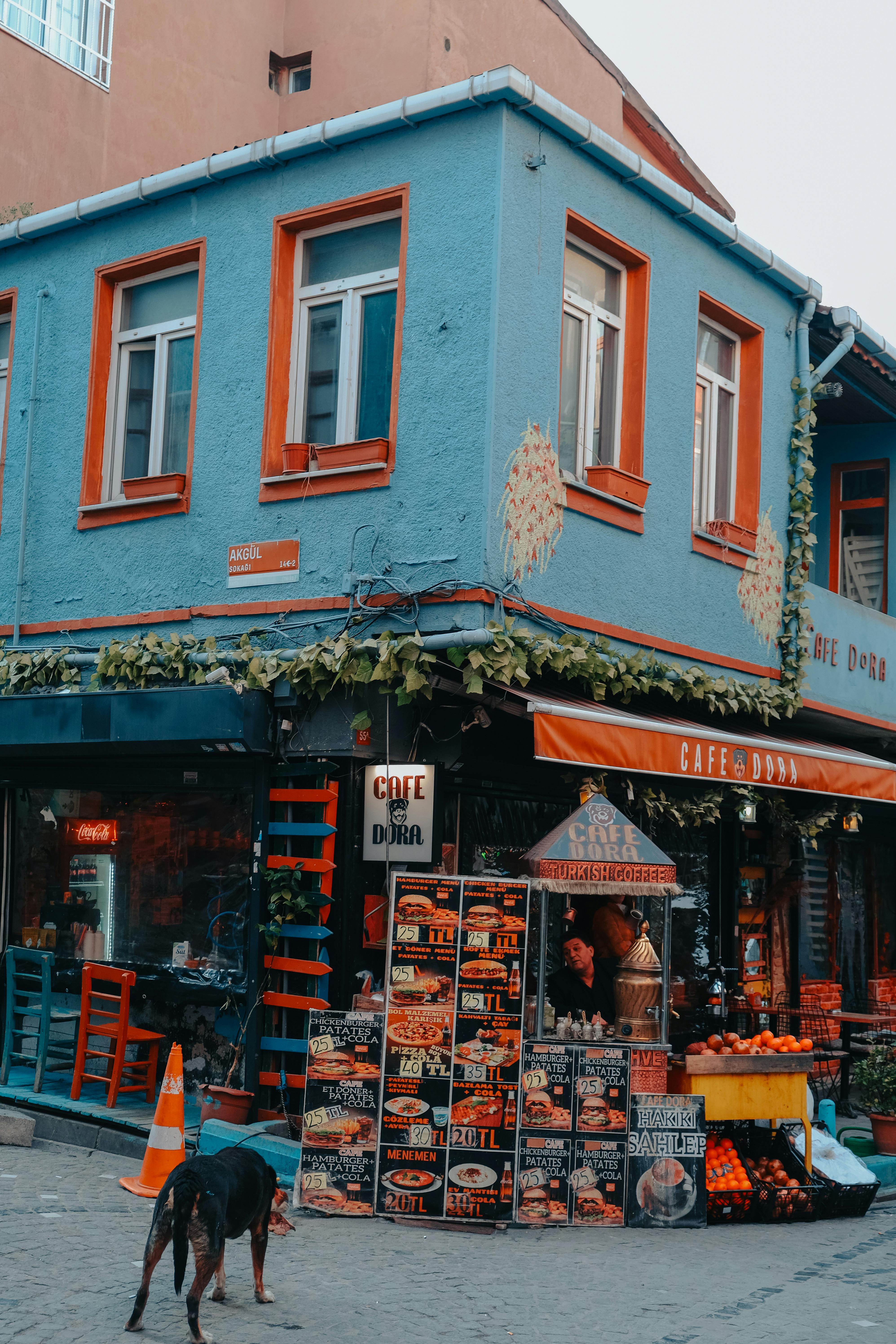 Free A colorful street corner featuring a vibrant café exterior with a lively urban setting. Stock Photo
