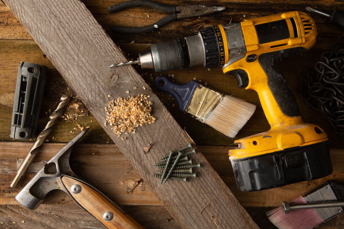 Cordless drill, hammer, and professional workshop tools arranged on a workbench