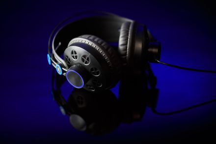Studio headphones lit by blue light, photo by Benjamin Lehman on Pexels