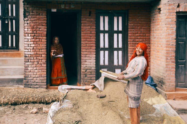 Woman Holding A Winnowing Basket With Grains