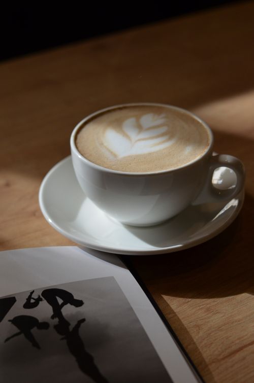 Free Capture of a latte with intricate art in a cozy cafe setting. Stock Photo