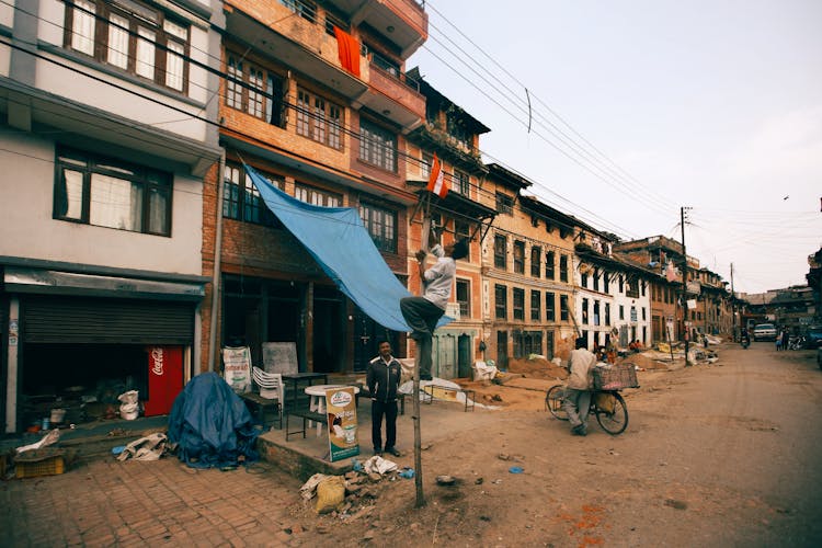 Man Climbing A Flagpole Near A Building