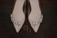 Wedding Rings Lying Between Pair of Transparent Heels