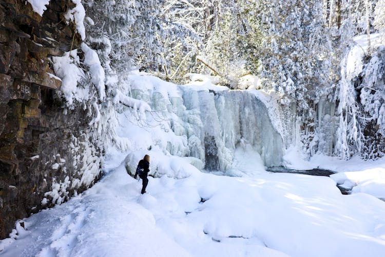 Person On Snow Covered Ground Near Rocky Mountain