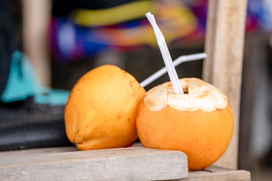 Close-up of fresh yellow coconuts with drinking straws, perfect for a tropical refreshment.