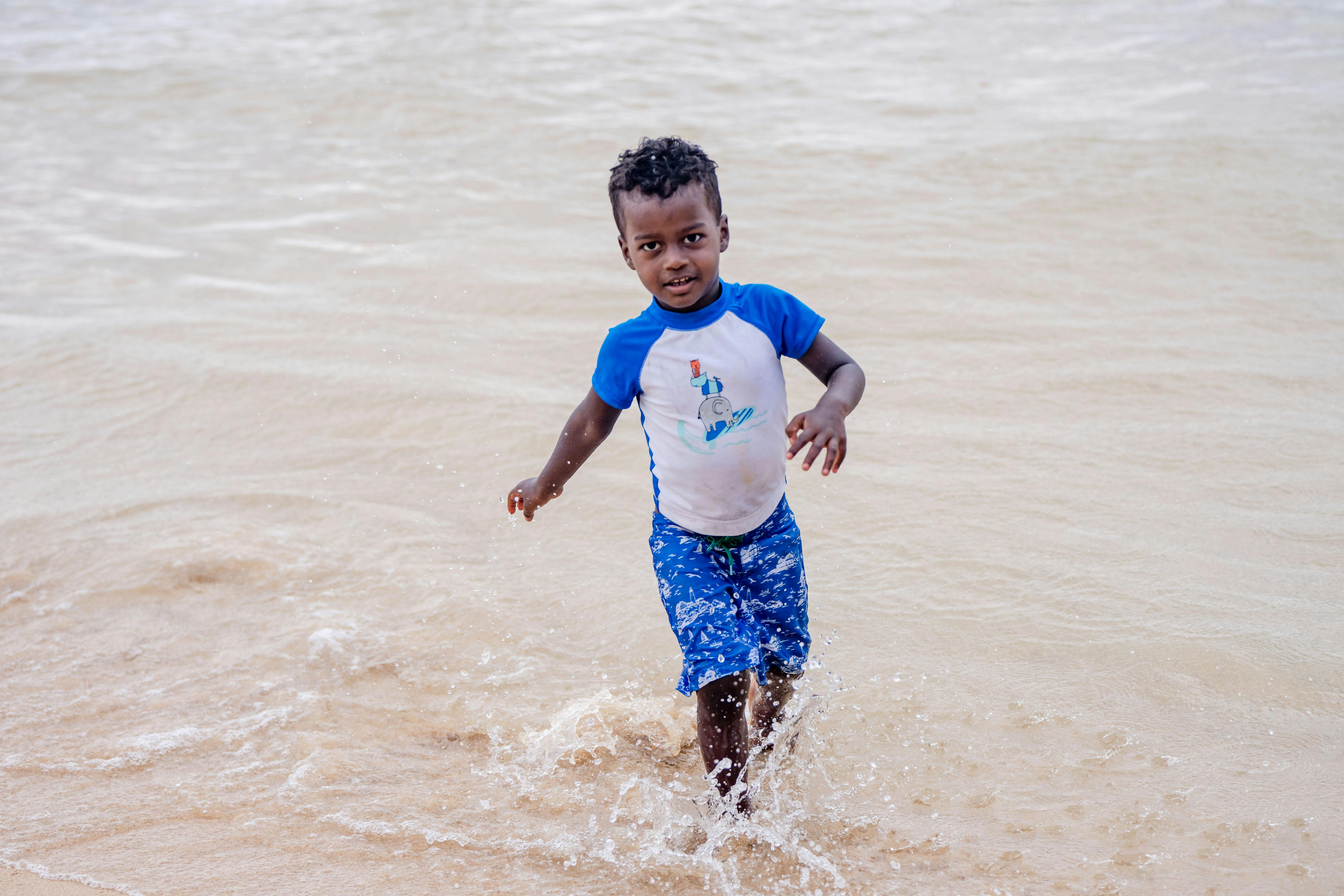 toddler playing calm beach shallow water