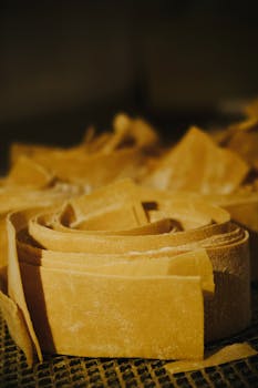 Macro shot of homemade pasta strips elegantly arranged against a dark backdrop.
