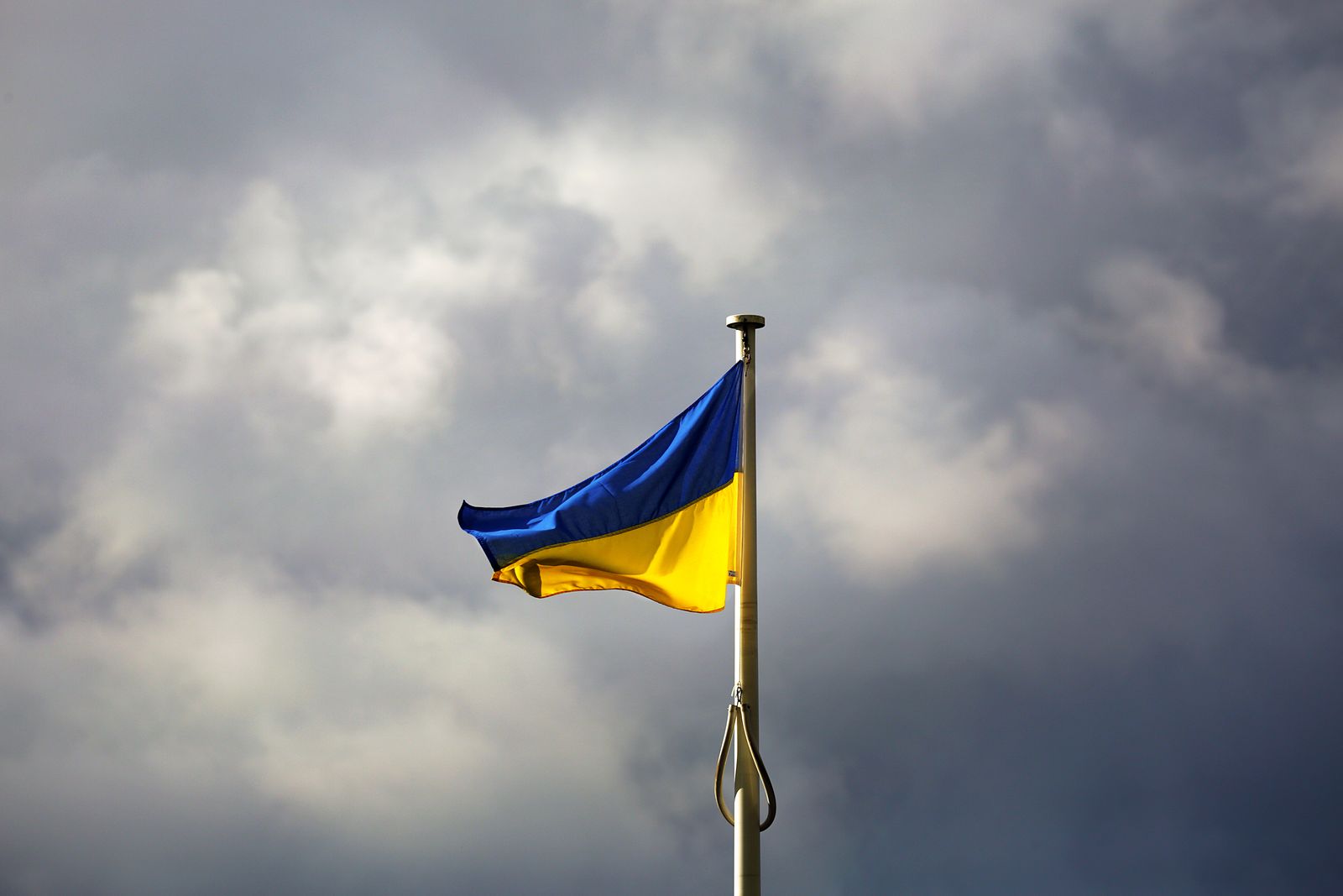 Ukrainian national flag against a dramatic cloudy sky.