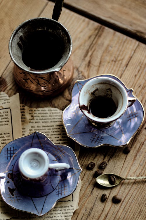 A Cup of Dark Drink on a Wooden Table