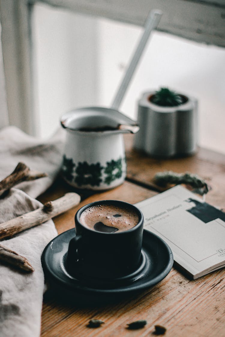 Cup Of Coffee On Messy Table By Window