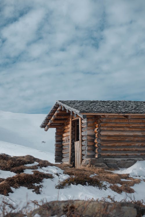 A  Wooden Cabin on Snow Covered Ground During Winter