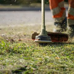 Close-up of a trimmer head cutting grass