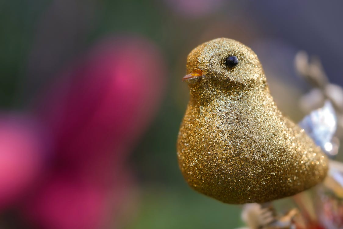 Close Up Photo of a Golden Bird Figurine