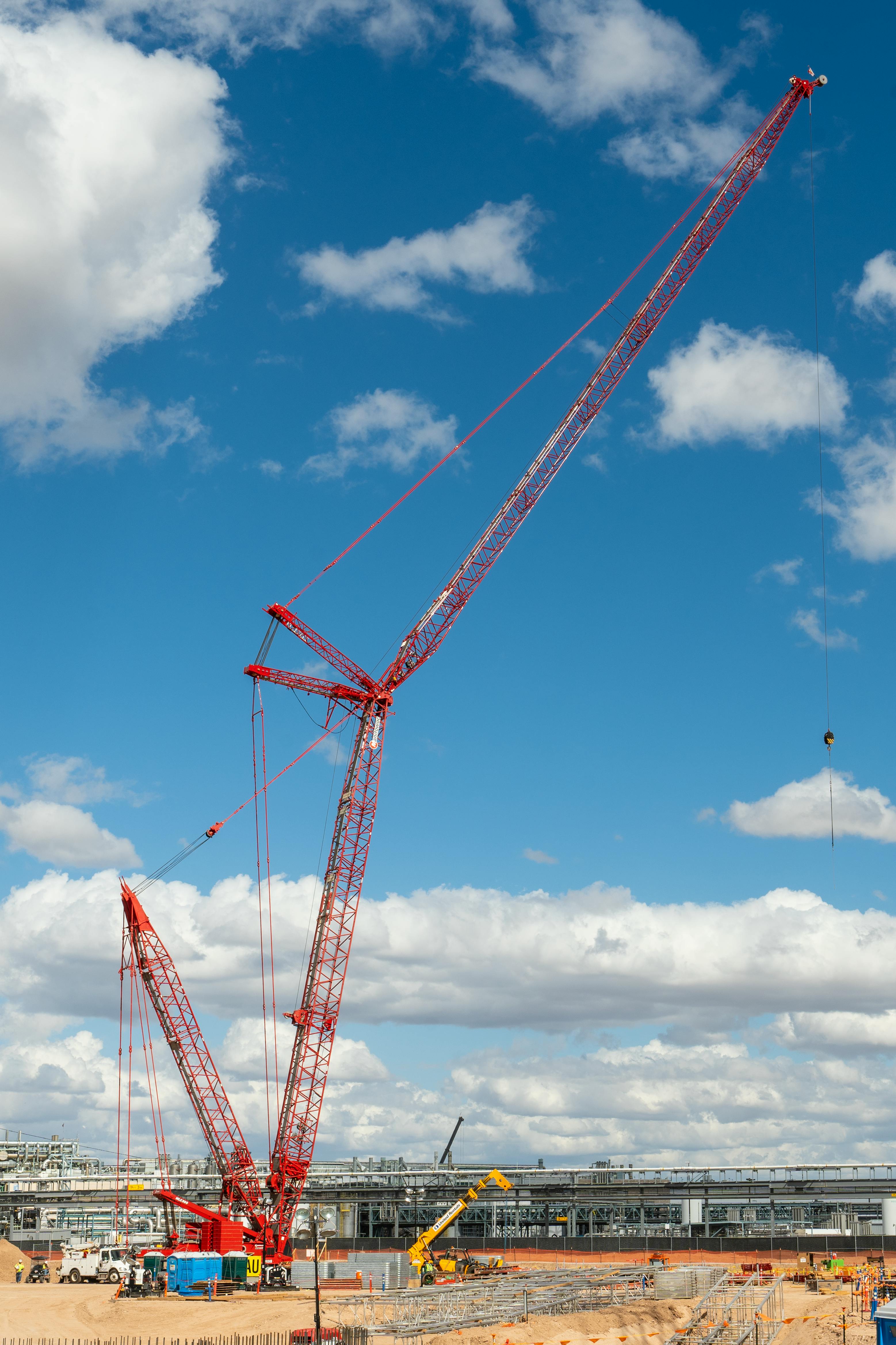 Green Tower Crane on a Background of Clouds Stock Photo