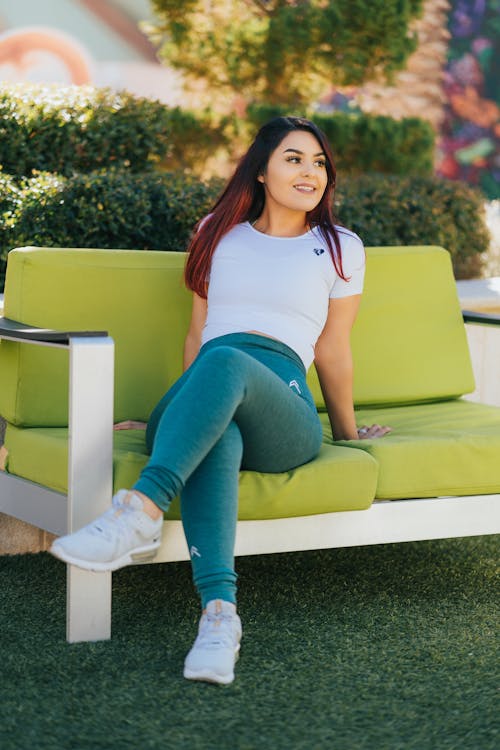 Woman in White Shirt Sitting on Green Sofa