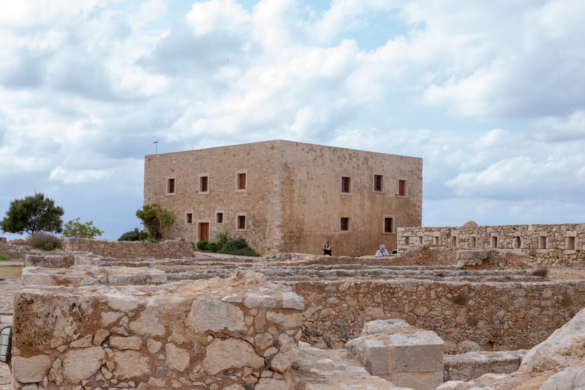 A historic ancient building with stone ruins under an overcast sky, showcasing rustic architecture.