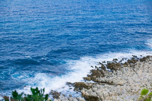 Free A captivating view of the rocky coastline with crashing waves and deep blue waters of the Aegean Sea in Crete, Greece. Stock Photo