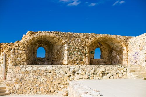 Free Explore ancient stone ruins with arched windows against a vibrant blue sky, showcasing history and architecture. Stock Photo