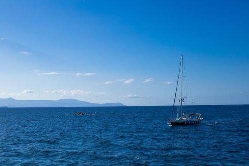 Free Peaceful image of a sailboat on the open sea under a clear blue sky. Stock Photo