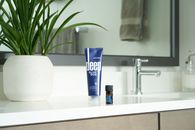 Blue and White Plastic Tube Bottle on White Ceramic Sink