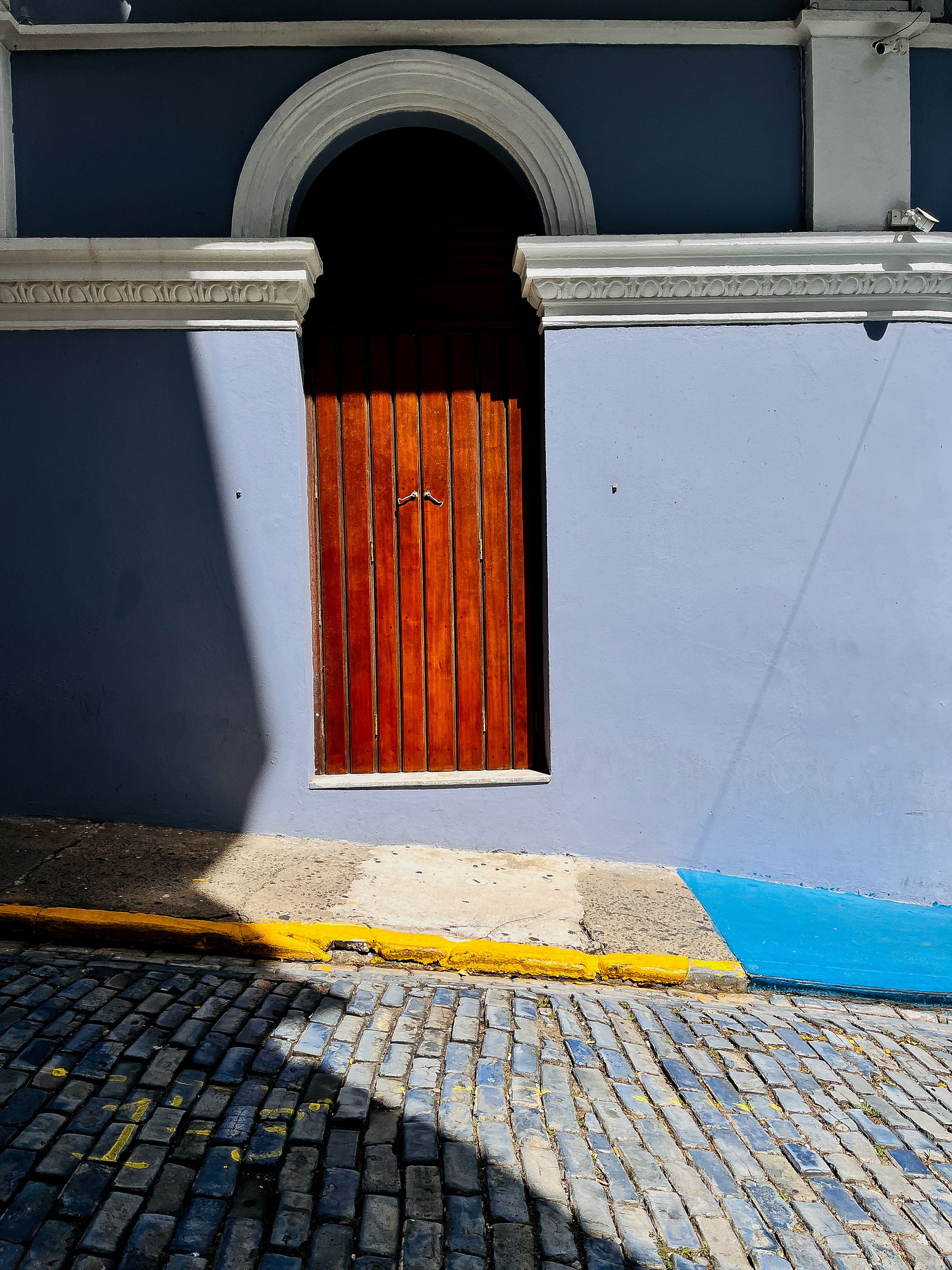 An arched wooden door in a colorful colonial building in San Juan, Puerto Rico
