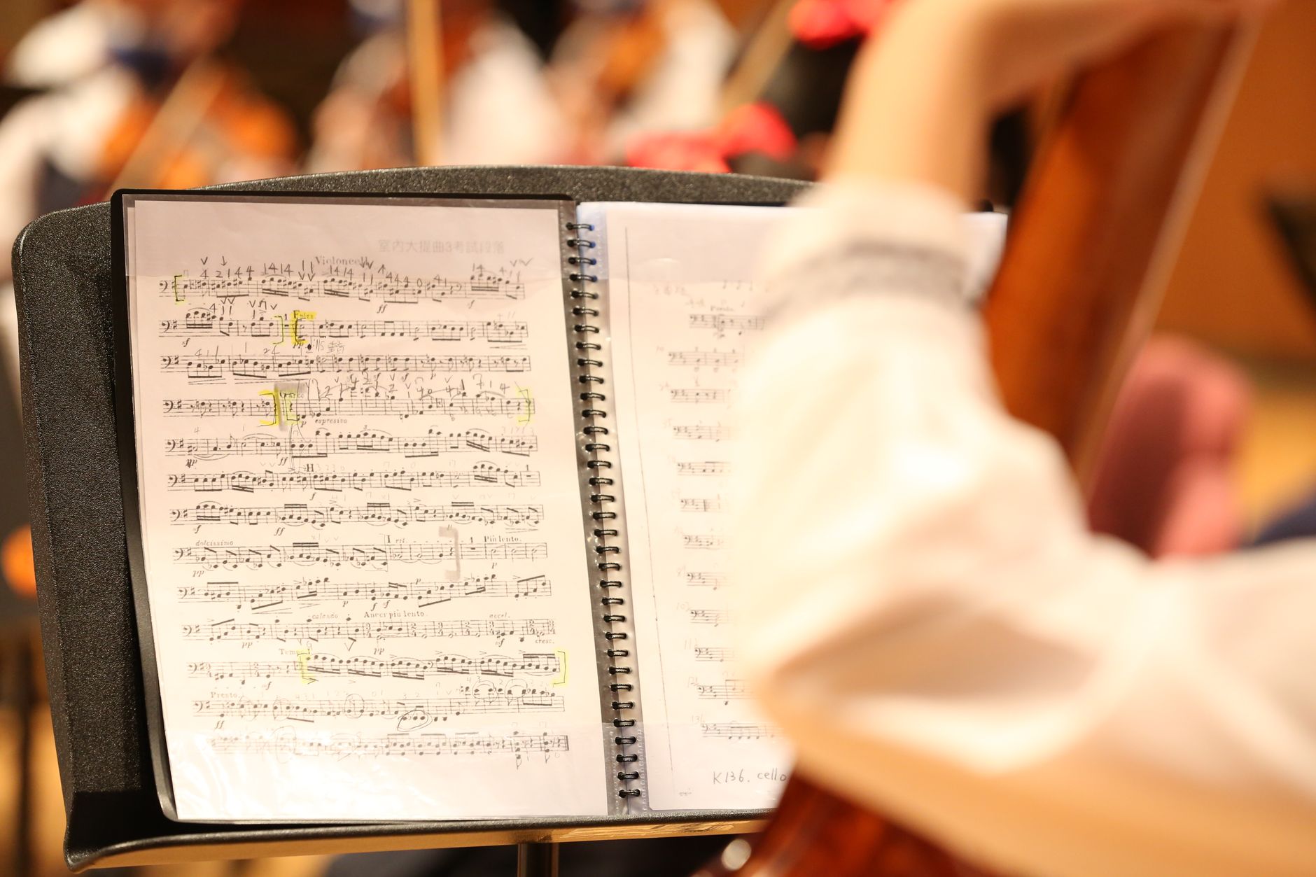 Detailed view of musical notes on sheet music during an orchestra rehearsal.