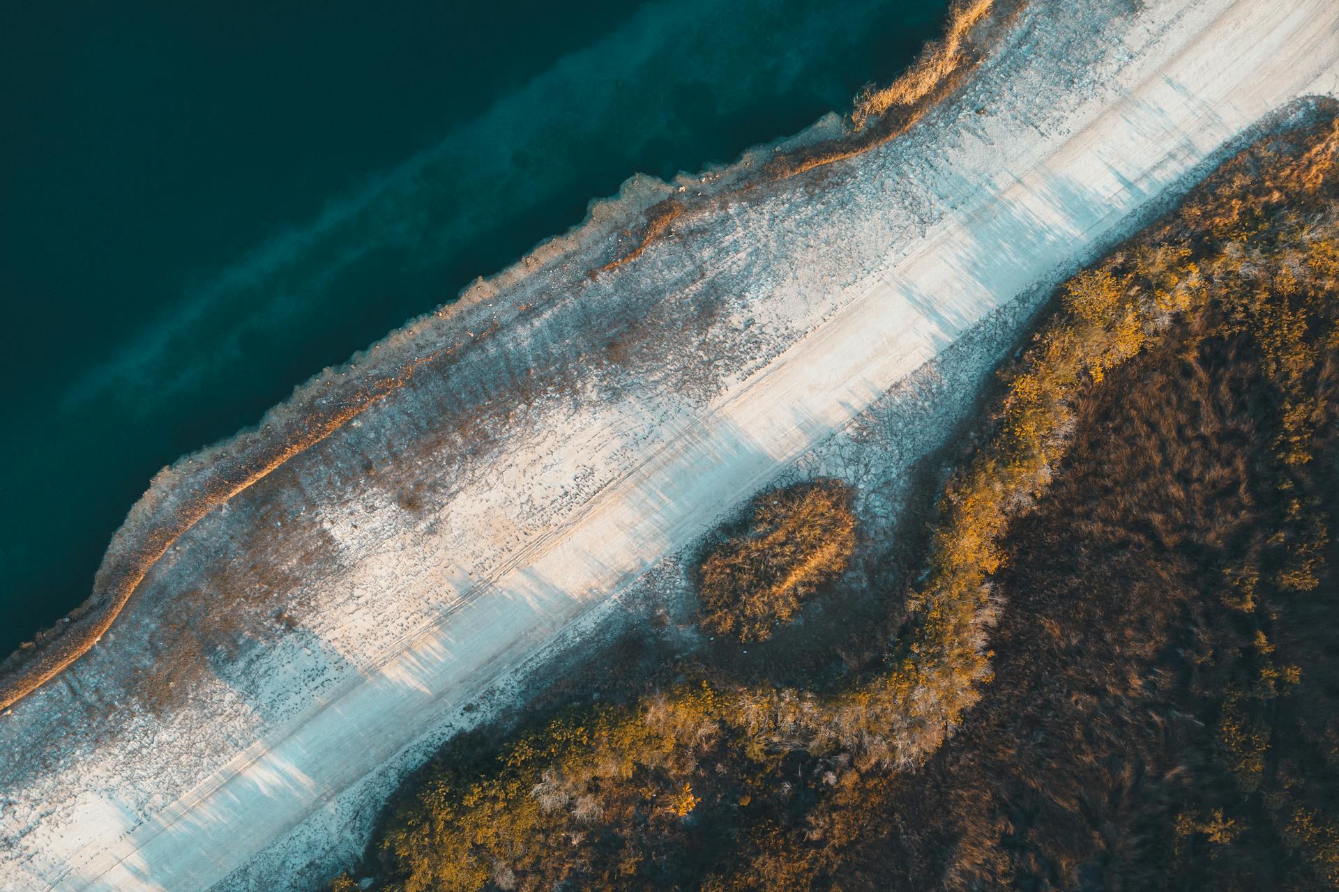 Drone view of a serene Florida coastline with contrasting water and land textures.