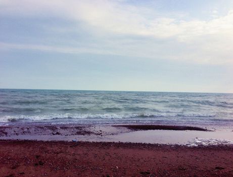 Serene beach with gentle waves under a calming sky, perfect for nature themes.