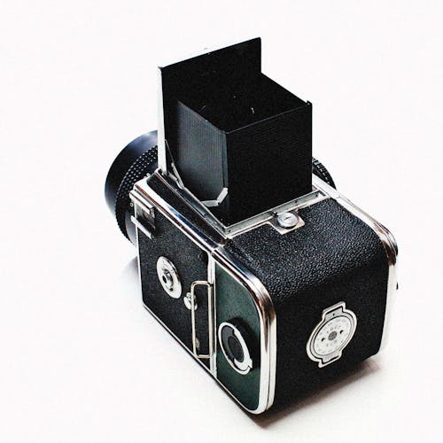 Close-Up Shot of a Black Vintage Camera on a White Surface