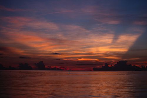 Free A breathtaking view of a tranquil sea at sunset with vibrant sky colors and calm waters. Stock Photo