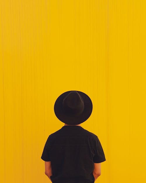 Imagine de stoc gratuită din cu pălărie largă, fotografiere verticală, fundal galben
