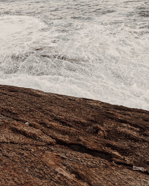 Ocean Waves Crashing on Brown Rock