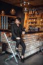 Man in Black Suit Sitting on Brown Wooden Chair