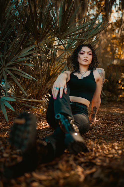 Woman in Her Black Spaghetti Strap Sitting on the Ground