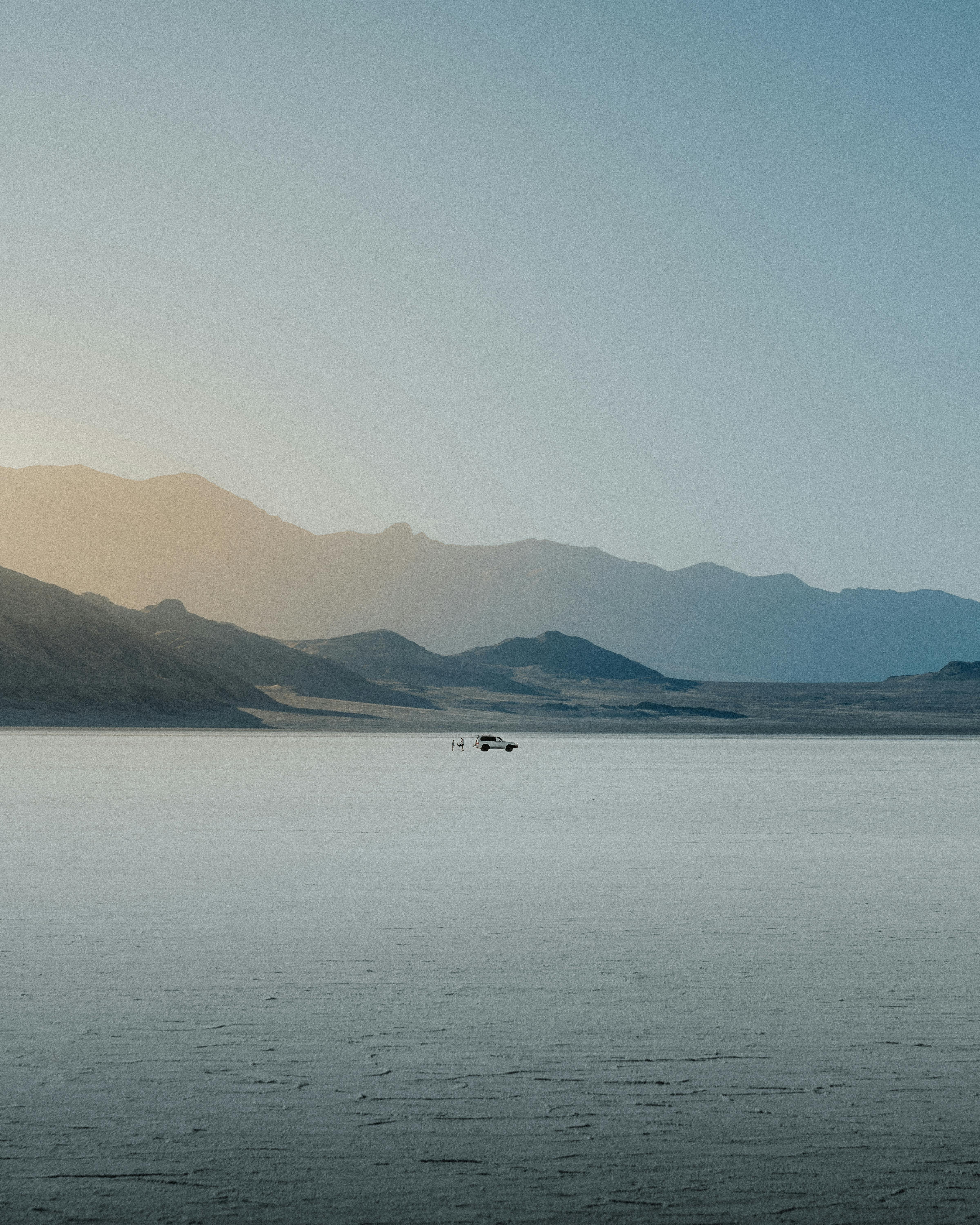 Serene sunrise over expansive Utah landscapes, highlighting mountains and open water.