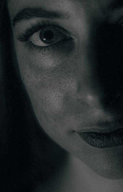 Free Dramatic black and white close-up of a woman's eye and half face. Stock Photo