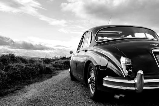 A classic vintage car parked on a scenic Irish road, captured in striking black and white.