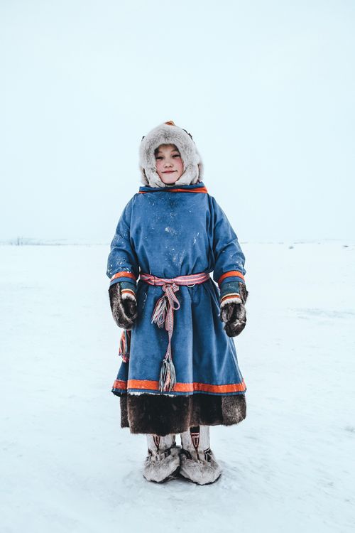 Free Portrait of a child in traditional Siberian clothing standing in a snowy landscape. Stock Photo