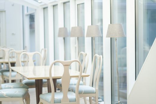 Pale breakfast room with pastel chairs by the glazing. Photo: Katrīne Skrebele on Pexels