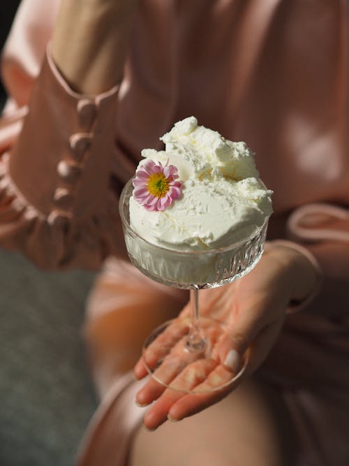 Selective Focus of a Person Holding a White Ice Cream in Coupe Glass