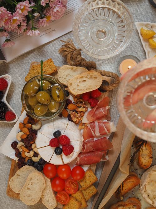 Free A beautifully arranged charcuterie board featuring cheeses, olives, nuts, and cured meats for a gourmet treat. Stock Photo