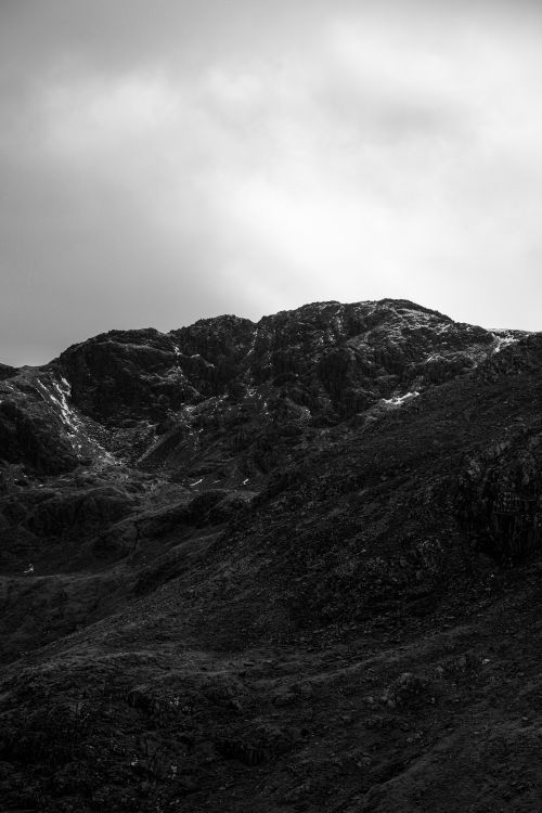 Free Monochrome mountain scene showcasing rocky terrain under a cloudy sky Stock Photo