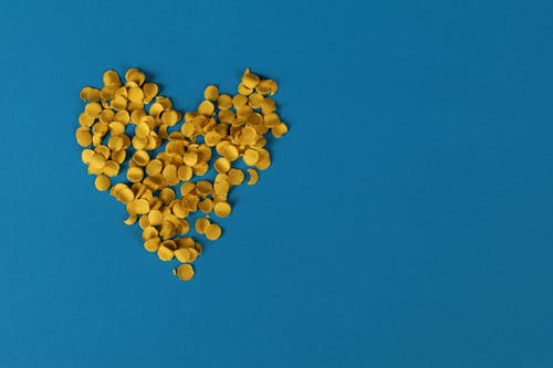 Yellow Petals in Heart Shape on Blue Background