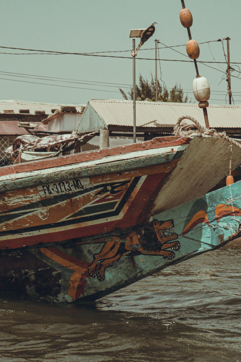 Pabifaye Vibrantly painted traditional fishing pirogue boat moored in the waters of Fatick Senegal