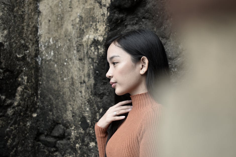 Side profile of a woman wearing a turtleneck sweater against a rugged outdoor backdrop.