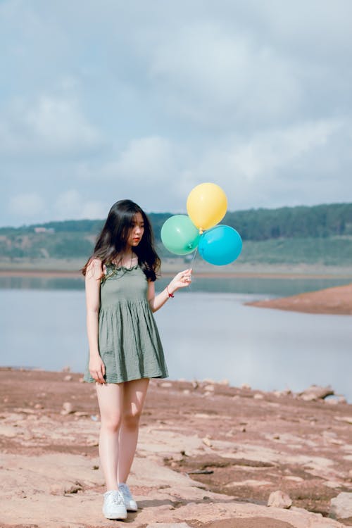 免費 拿著氣球的綠色無袖連衣裙的女人 圖庫相片